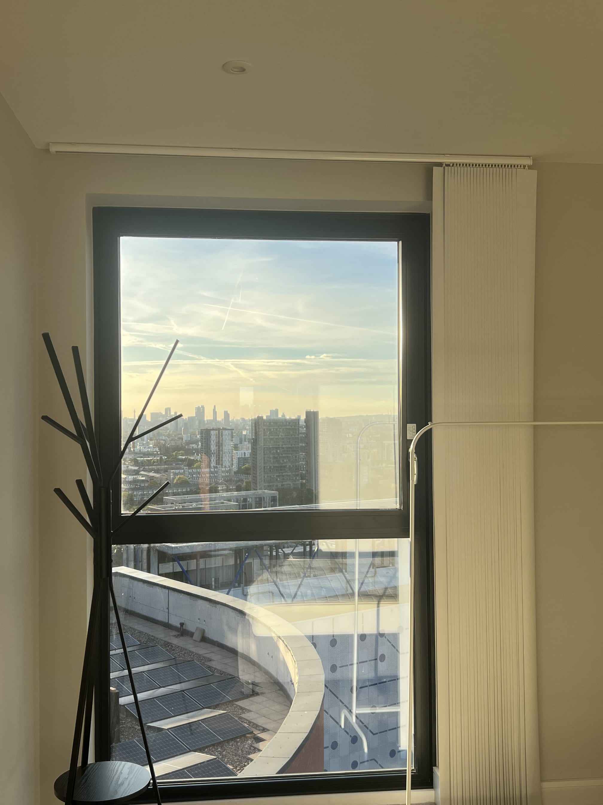 Tall window in a high-rise flat looking out over the London skyline